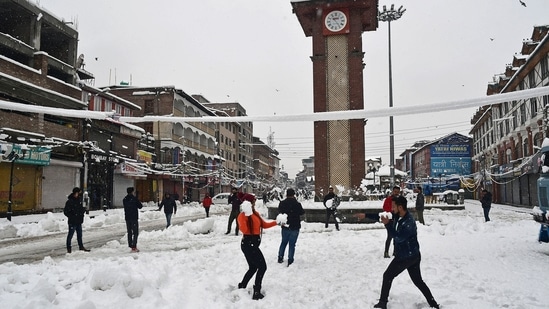 Tourists enjoy at Lal Chowk after a heavy snowfall, in Srinagar on February 23.(ANI)