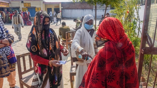 A voter undergoes thermal screening as she arrives at a polling station to cast her vote for the fourth phase of Uttar Pradesh Assembly polls, in Unnao.(PTI)
