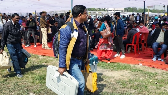 Polling officials carrying EVMs and other equipment for the fourth phase of the Uttar Pradesh Assembly Election in Lucknow on Tuesday. (Agency)(HT_PRINT)