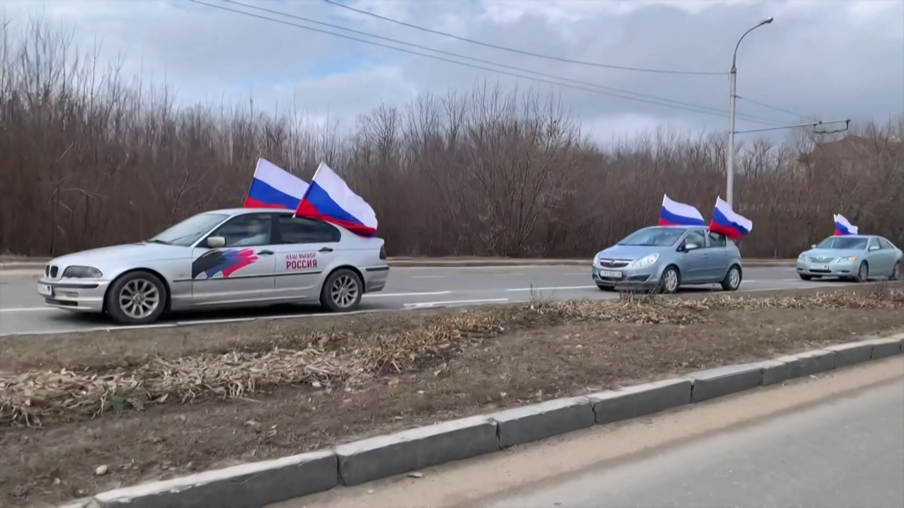 An image grab obtained from amateur footage shot shows a convoy of cars bearing Russian flags driving through the streets of Donetsk. (AFP)