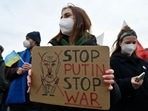 A woman holds a poster asking to "Stop Putin - Stop War" as demonstrators protest against Russia's invasion of Ukraine in front of the Brandenburg Gate in Berlin.