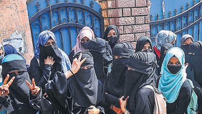 Students stand outside a college as they boycott classes after being denied entry with hijab in the college premises, in Chikmagalur. (PTI) Students stand outside a college as they boycott classes after being denied entry with hijab in the college premises, in Chikmagalur. (PTI)