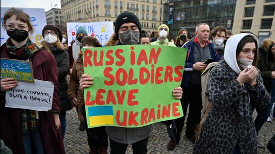 A man holds a placard reading ‘Russian Soldiers Leave Ukraine’ as demonstrators protest against Russia's invasion of Ukraine on Thursday in front of the Brandenburg Gate in Berlin. (AFP)