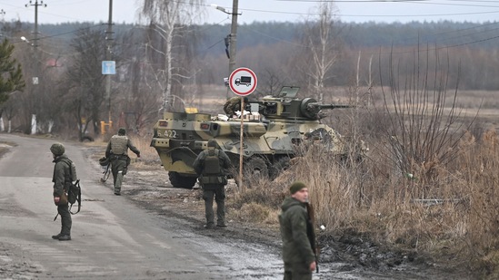 Ukrainian servicemen stand near an armored personnel carrier BTR-3 on the northwest of Kyiv.(AFP)