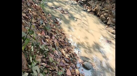 Dombivli MIDC residents wake up to toxic smell, watery eyes on Thursday. The residents also complained that the nullah water flowing in the area has turned white. (HT PHOTO)