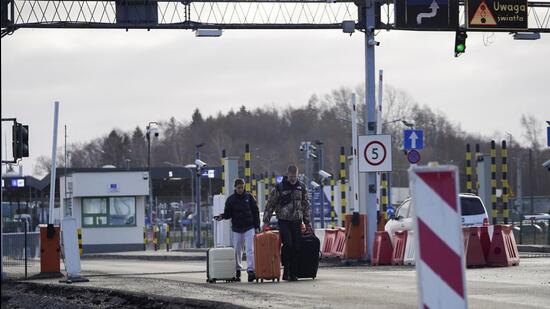 An American couple walks with their luggage after fleeing the violence in Ukraine, in Medyka, Poland, February 24, 2022. REUTERS/Bryan Woolston (REUTERS)