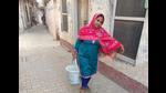 A woman carries a bucket of water in Dugri area of Ludhiana. (HT Photo) A woman carries a bucket of water in Dugri area of Ludhiana. (HT Photo)