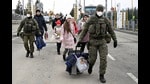 Slovak customs officers help people to cross the border as they arrive from Ukraine to Slovakia, after Russia launched a massive military operation against Ukraine, in Vysne Nemecke, Slovakia. (REUTERS) Slovak customs officers help people to cross the border as they arrive from Ukraine to Slovakia, after Russia launched a massive military operation against Ukraine, in Vysne Nemecke, Slovakia. (REUTERS)