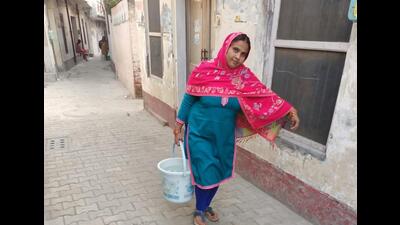 A woman carries a bucket of water in Dugri area of Ludhiana. (HT Photo)