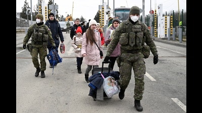 Slovak customs officers help people to cross the border as they arrive from Ukraine to Slovakia, after Russia launched a massive military operation against Ukraine, in Vysne Nemecke, Slovakia. (REUTERS)