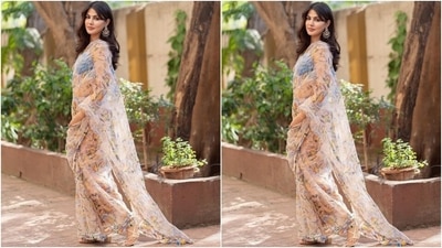 The blush pink georgette saree comes adorned with floral print in yellow, orange, blue and green shades, beadwork on the borders running across the hem and pallu, and dangling tassels. She teamed it with a pastel blue cropped bralette featuring barely-there straps, beadwork on the bust, tie up at the back, and a V neckline. (Instagram/@rhea_chakraborty) The blush pink georgette saree comes adorned with floral print in yellow, orange, blue and green shades, beadwork on the borders running across the hem and pallu, and dangling tassels. She teamed it with a pastel blue cropped bralette featuring barely-there straps, beadwork on the bust, tie up at the back, and a V neckline. (Instagram/@rhea_chakraborty)