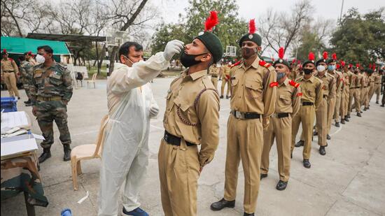 A health care worker collects a swab sample from an NCC cadet for a Covid-19 test at Nagrota in Jammu earlier this week. (PTI) A health care worker collects a swab sample from an NCC cadet for a Covid-19 test at Nagrota in Jammu earlier this week. (PTI)