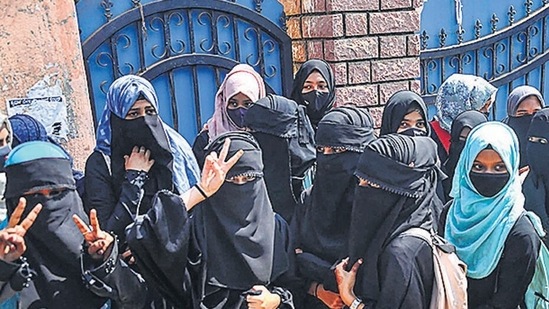 Students stand outside a college as they boycott classes after being denied entry with hijab in the college premises, in Chikmagalur. (PTI) Students stand outside a college as they boycott classes after being denied entry with hijab in the college premises, in Chikmagalur. (PTI)