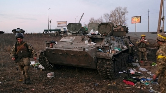 Ukrainian servicemen are seen next to a destroyed armoured vehicle, which they said belongs to the Russian army, outside Kharkiv, Ukraine.