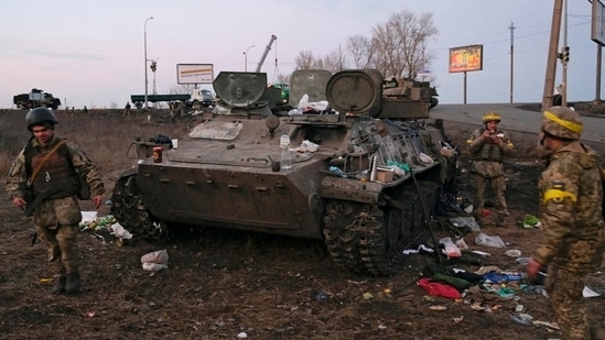 Ukrainian servicemen are seen next to a destroyed armoured vehicle, which they said belongs to the Russian army, outside Kharkiv, Ukraine.(REUTERS)