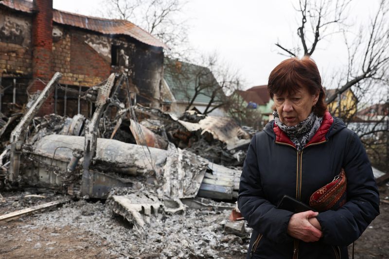 A woman walks around the wreckage of an unidentified aircraft that crashed into a house in a residential area in Kyiv, Ukraine (REUTERS)