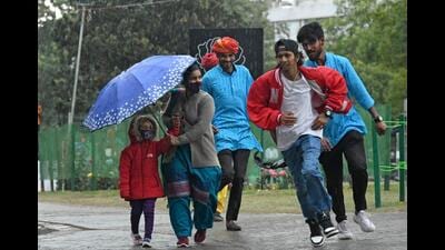 Rose Festival visitors rushing for cover amid the rain at the Zakir Hussain Rose Garden in Chandigarh on Saturday. The day temperature dropped by six degrees following the showers. (Ravi Kumar/HT)