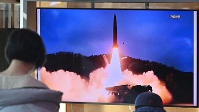 People watch a television screen showing a news broadcast with file footage of a North Korean missile test, at a railway station in Seoul on January 30, 2022. (AFP)