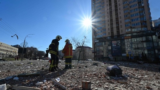 &nbsp;Firefighters work by a high-rise apartment block which was hit by recent shelling in Kyiv on Saturday.(AFP)