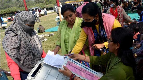 Polling officials check the Electronic Voting Machine (EVMs) at a distribution centre for the fifth phase of the Uttar Pradesh assembly elections, in Prayagraj on Saturday. (ANI)