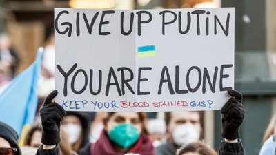 A rally participant holds up a sign reading "Give up Putin, you are alone" during a demonstration at the Rathausmarkt against the Russian attack on Ukraine in Hamburg, Germany, Sunday, February 27, 2022 (AP) A rally participant holds up a sign reading "Give up Putin, you are alone" during a demonstration at the Rathausmarkt against the Russian attack on Ukraine in Hamburg, Germany, Sunday, February 27, 2022 (AP)