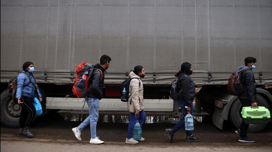 People fleeing Ukraine walk toward the Shehyni border crossing to Poland. (REUTERS)