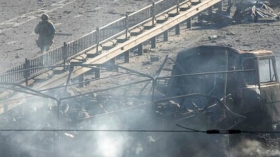 Ukrainian soldiers walk past debris of a burning military truck, on a street in Kyiv, Ukraine, Saturday, Feb. 26, 2022. (AP Photo/Efrem Lukatsky)(AP)