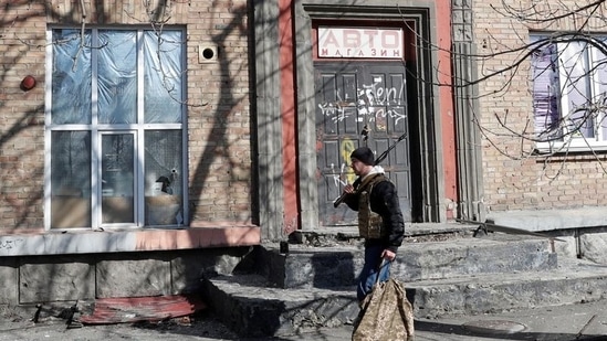 A member of the Ukrainian Territorial Defence Forces walks near the site of night fighting with Russian troops, after Russia launched a massive military operation against Ukraine, in Kyiv.(REUTERS)