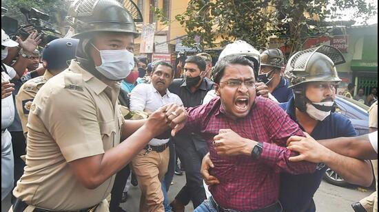 Police detain an activist during BJP's march towards Lalbazar (Kolkata Police headquarters) to protest against the alleged violence during the ongoing West Bengal civic polls in Kolkata on Sunday. (PTI PHOTO.)
