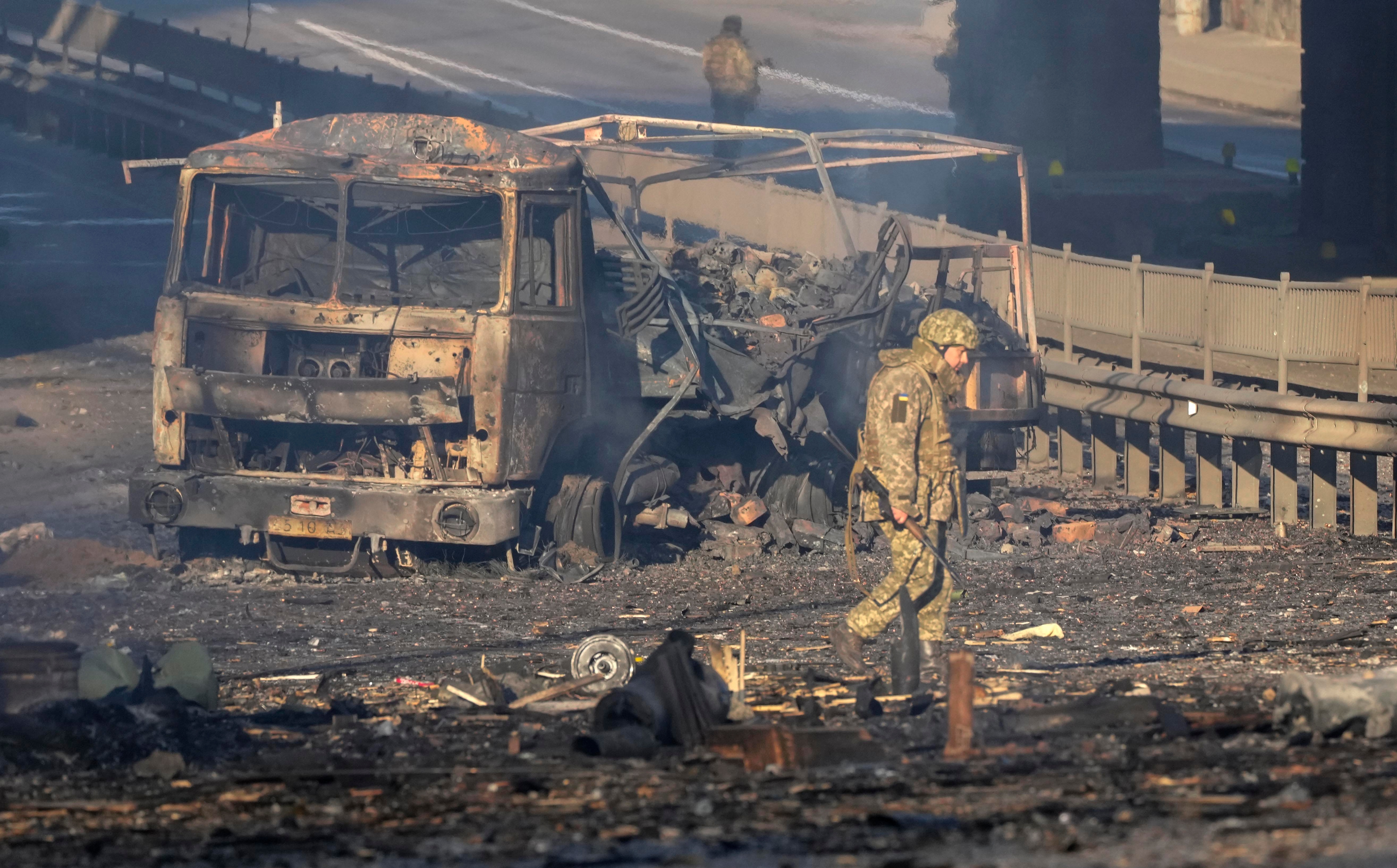 A Ukrainian soldier walks past debris of a burning military truck, on a street in Kyiv on February 26, 2022. (AP) A Ukrainian soldier walks past debris of a burning military truck, on a street in Kyiv on February 26, 2022. (AP)