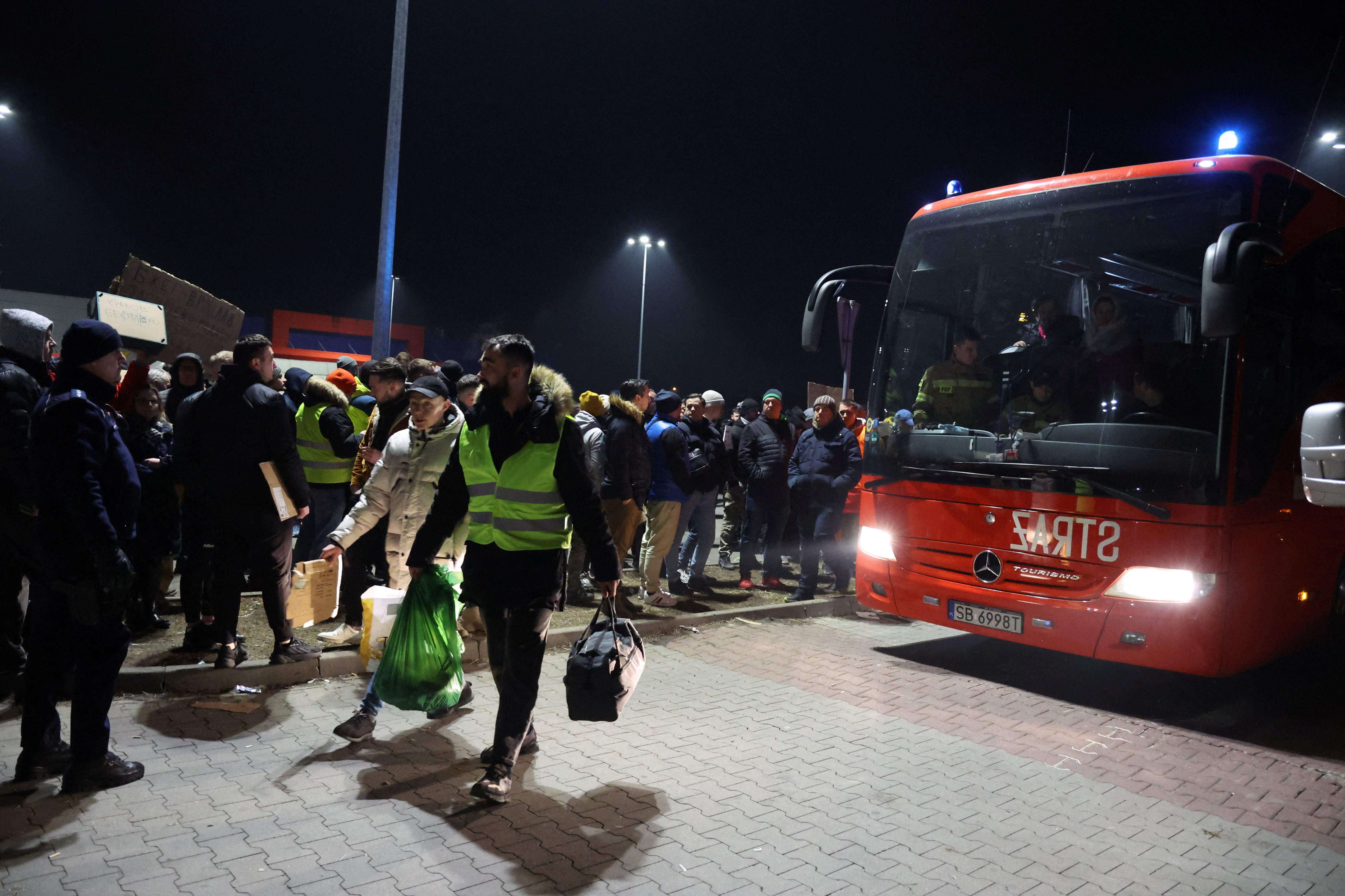 Przemysl, Poland: People wait in a parking lot for buses to arrive with refugees after Russia's invasion against Ukraine on February 26, 2022.&nbsp; (Reuters photo)