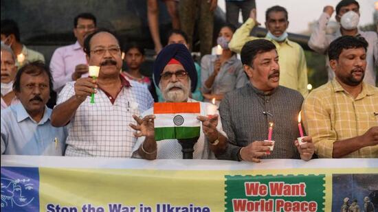Activists of the All India Peace and Solidarity Organisation hold banners and light candles in Hyderabad on Monday, in support of world peace following the Russian invasion in Ukraine. (AFP)