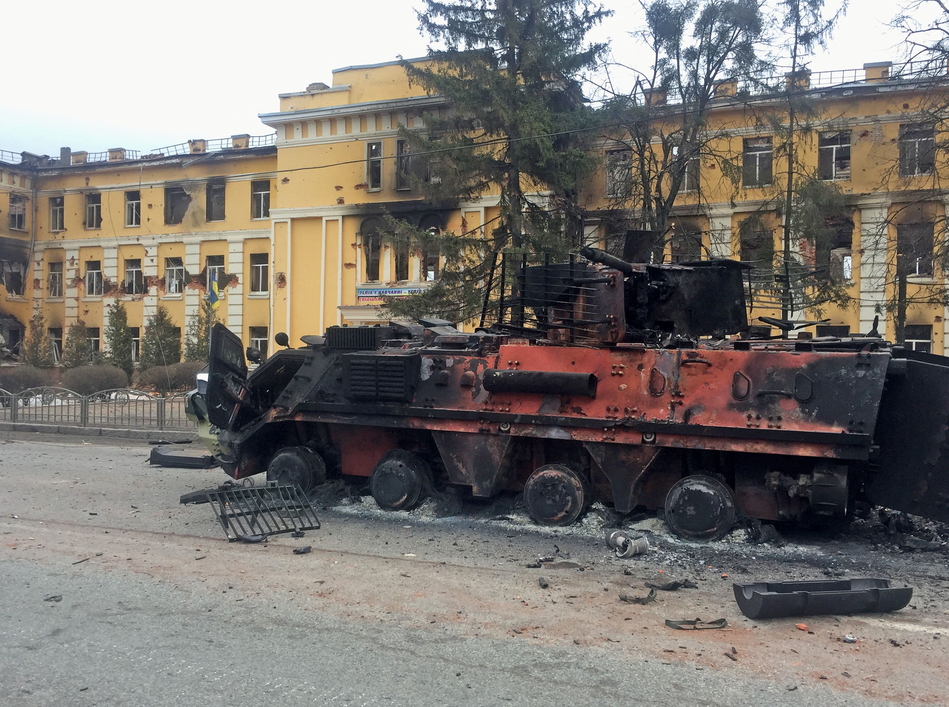 A destroyed armoured vehicle is seen in front of a school which, according to local residents, was on fire after shelling in Kharkiv, Ukraine. (REUTERS)
