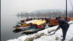 Srinagar: A shikara-walla removes snow from the snow-covered banks of Dal Lake, after sudden heavy snowfall, in Srinagar, Thursday, Feb 24, 2022. (PTI Photo)(PTI02_24_2022_000130B) (PTI) Srinagar: A shikara-walla removes snow from the snow-covered banks of Dal Lake, after sudden heavy snowfall, in Srinagar, Thursday, Feb 24, 2022. (PTI Photo)(PTI02_24_2022_000130B) (PTI)