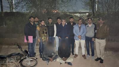 The police team with the two suspects. According to the police, at least 22 bullets were exchanged between a police team and the two gangsters before they were arrested. (Sourced) The police team with the two suspects. According to the police, at least 22 bullets were exchanged between a police team and the two gangsters before they were arrested. (Sourced)