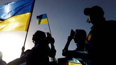 Ukrainians and supporters wave Ukrainian flags during an anti-war protest outside the Russian Embassy. (REUTERS)