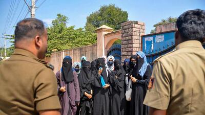 Policemen talk to the students who boycotted classes after being denied entry with 'hijab' in the college premises, in Chikmagalur, on February 21. (PTI) Policemen talk to the students who boycotted classes after being denied entry with 'hijab' in the college premises, in Chikmagalur, on February 21. (PTI)
