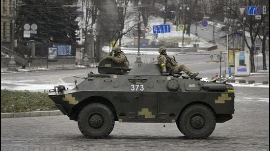 Ukrainian servicemen ride on top of an armoured personnel carrier speeding down a deserted boulevard during an air raid alarm, in Kyiv, Ukraine, on Tuesday. (AP)