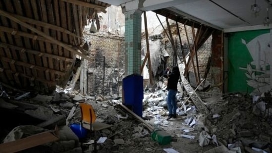 A woman takes photos of a destroyed accommodation building near a checkpoint in Brovary, outside Kyiv, Ukraine,(AP)