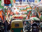 People commuting on a road displaying flags of various parties during the West Bengal civic polls, at Chandannagar, in Hooghly on Sunday. (ANI PHOTO.)