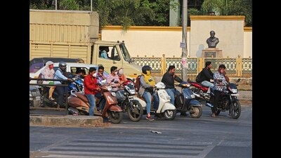 Commuters are seen without helmets as they halt at a red light in front of Rajiv Gandhi zoological park along Pune-Satara road Wednesday. (Ravindra Joshi/HT PHOTO) Commuters are seen without helmets as they halt at a red light in front of Rajiv Gandhi zoological park along Pune-Satara road Wednesday. (Ravindra Joshi/HT PHOTO)