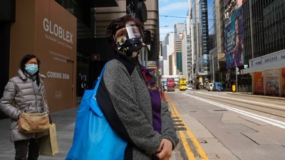 People wearing face masks walk at a downtown street in Hong Kong. (AP) People wearing face masks walk at a downtown street in Hong Kong. (AP)