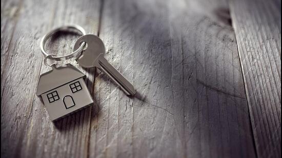 House key on a house shaped keychain resting on wooden floorboards concept for real estate, moving home or renting property (Getty Images/iStockphoto)