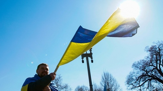 A demonstrator holds a Ukrainian flag during a "Stand with Ukraine" rally against the Russian invasion of Ukraine, in front of the White House in Washington, US, Monday.&nbsp;(REUTERS)