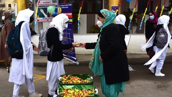 Students queued up for the screening of body temperature before entering the school premises as part of the anti-covid standard operating procedure.(HT Photo/Waseem Andrabi)