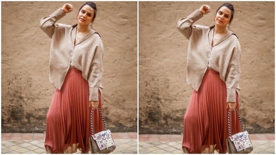 Neha Dhupia's outfit comprised of a neutral oversized shirt and an orange pleated skirt.(Instagram/@nehadhupia)