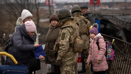 Ukrainian soldiers check people's identity cards as they flee their neighborhoods, on the outskirts of Kyiv on March 2, 2022.&nbsp;(AP)