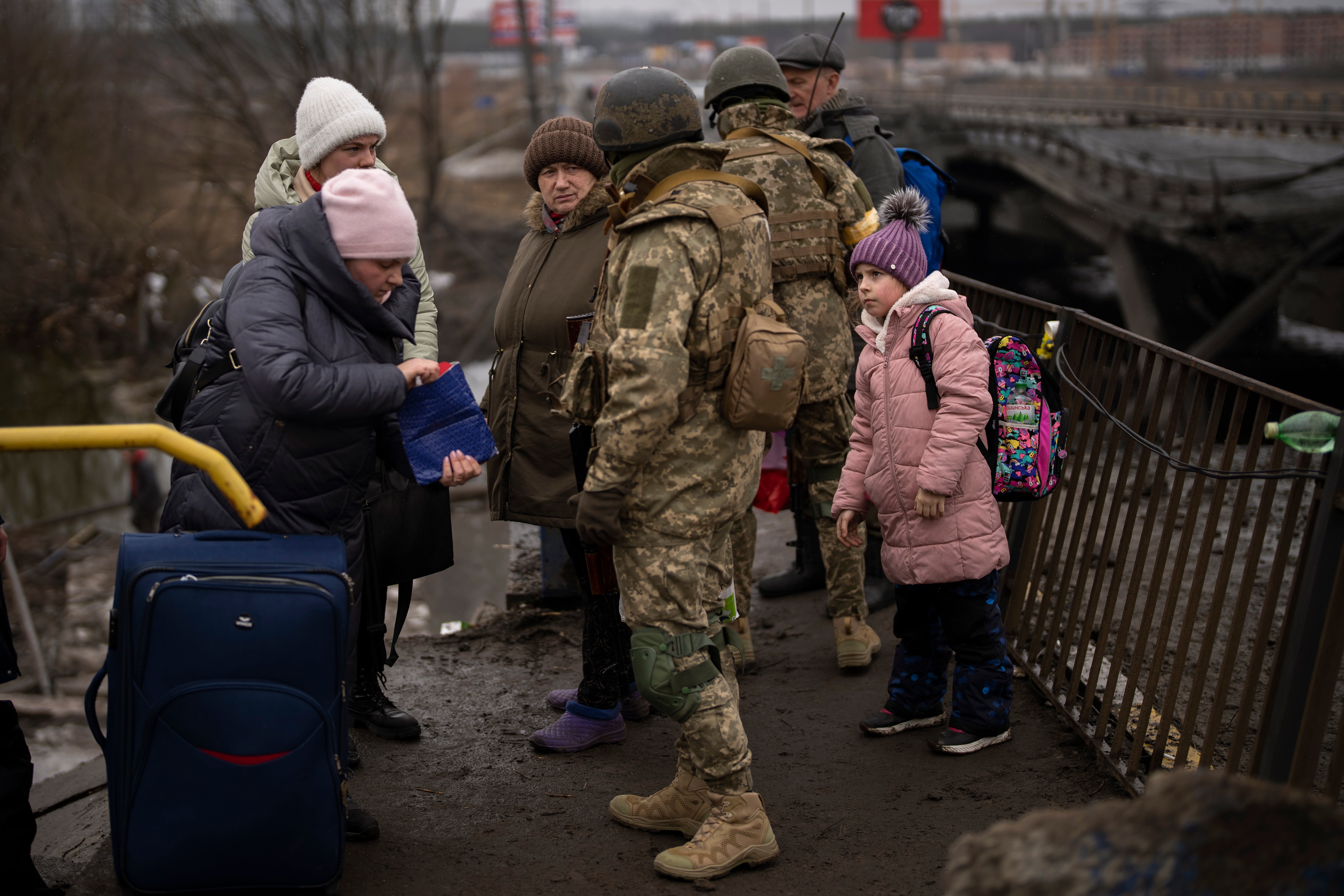 Ukrainian soldiers check people's identity cards as they flee their neighborhoods, on the outskirts of Kyiv on March 2, 2022. (AP) Ukrainian soldiers check people's identity cards as they flee their neighborhoods, on the outskirts of Kyiv on March 2, 2022. (AP)