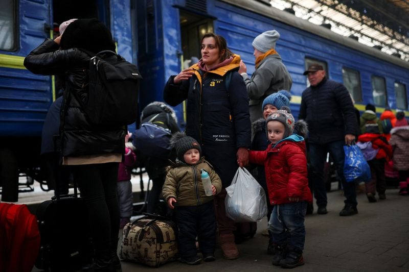 A family fleeing Russian invasion of Ukraine arrives at a train station in Lviv, Ukraine. (Reuters photo)