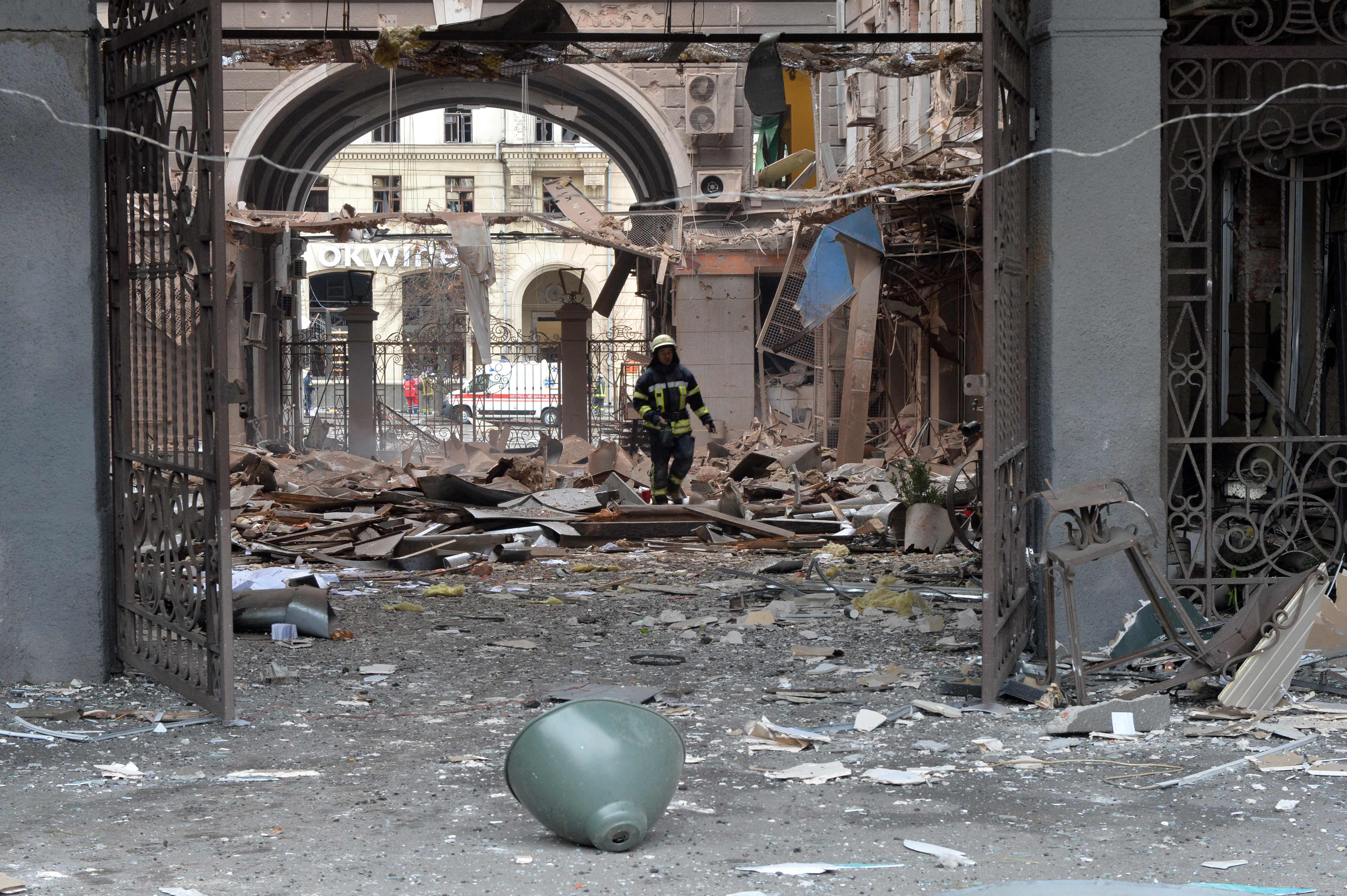 A firefighter walks through a damaged building entrance in Kharkiv, Ukraine.